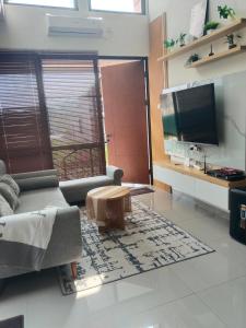 a living room with a couch and a tv at Shania home in Bogor