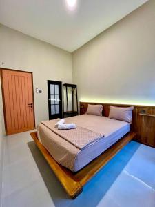 a bedroom with a bed with a wooden frame at Lepen Home in Ngabean