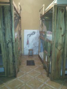 a room with two bunk beds and a stool at La Choza Guesthouse in Santo Domingo