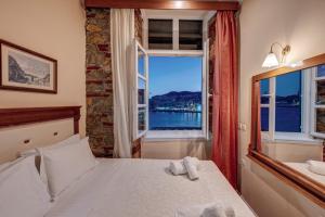 a bedroom with a bed and a window with a view at Hotel Aktaion Syros in Ermoupoli