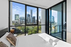 a bedroom with a white bed and a large window at Brisbane Skyline View 2Beds River view Apt in Brisbane +33 photos