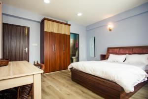 a bedroom with a large bed and a desk at Jhigu Casa Homestay in Kirtipur