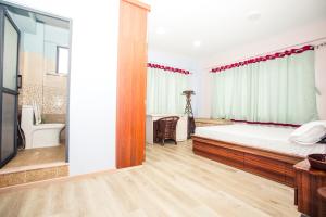 a bedroom with a large bed and a bathroom at Jhigu Casa Homestay in Kirtipur +34 photos