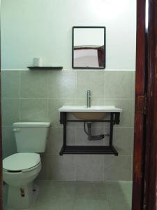 a bathroom with a toilet and a sink at Hotel Don Candido in Tuxtla Gutiérrez