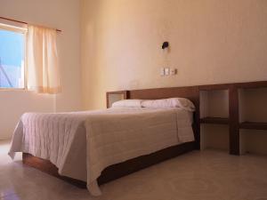 a bedroom with a large bed with a window at Hotel Don Candido in Tuxtla Gutiérrez