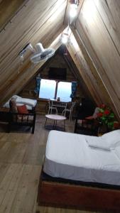 a attic bedroom with two beds and a table at Mi Terraza Hostel in Almirante