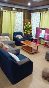 a living room with couches and a table and a tv at Mi Terraza Hostel in Almirante