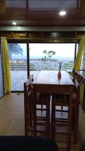 a table and chairs in a room with a view of the ocean at Mi Terraza Hostel in Almirante