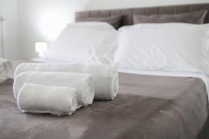 two stacks of towels sitting on top of a bed at Airport bari grey in Bari +66 photos