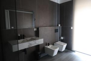 a bathroom with a toilet and a sink and a mirror at Airport bari grey in Bari