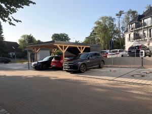 a parking lot with cars parked under a carport at Appartement Am Sandhuf in Lubmin