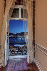a room with a window with a view of the water at Hotel Aktaion Syros in Ermoupoli