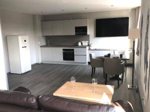 a living room with a couch and a table and a kitchen at Appartement Am Sandhuf in Lubmin