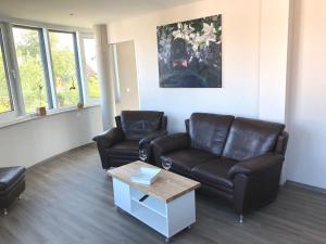 a living room with two leather couches and a coffee table at Panorama Suite in Lubmin