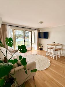 a living room with a couch and a table at Sussex View - Waterfront Couples Retreat in Sussex Inlet in Sussex Inlet