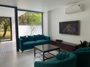 a living room with two blue couches and a table at Sunrise Beach House 1 in Tiến Thành