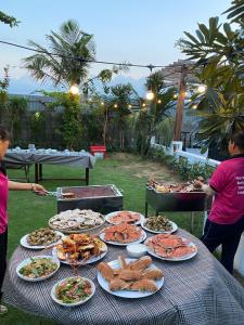 a table with many plates of food on it at Sunrise Beach House 1 in Tiến Thành