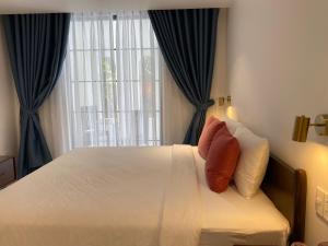 a bedroom with a bed with blue curtains and a window at Sunrise Beach House 1 in Tiến Thành +9 photos