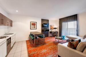 a kitchen and living room with a couch and a table at Miller Apartments in Adelaide