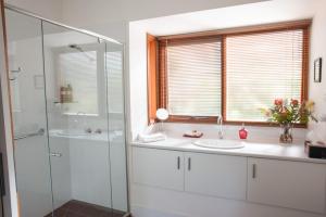 a bathroom with a sink and a glass shower at TorquayToongahra BnB in Torquay