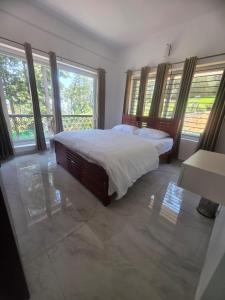 a bedroom with a large bed and windows at Shans Valley in Kotagiri +97 photos