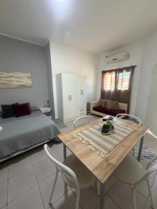 a bedroom with a bed and a wooden table and chairs at La Esquina AT in San Pedro