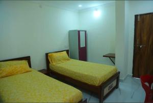 a room with two beds with yellow sheets on them at Prime PG - Coliving Hostel in Hyderabad