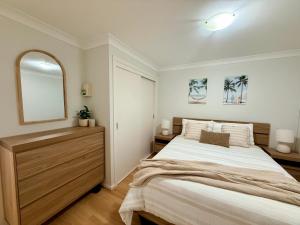 a bedroom with a large bed and a mirror at Sussex View - Waterfront Couples Retreat in Sussex Inlet in Sussex Inlet
