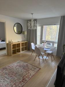 a living room with a table and chairs and a chandelier at Paimenkatu 1 in Savonlinna