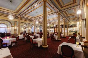 a restaurant with white tables and chairs in a building at Carrington Hotel in Katoomba