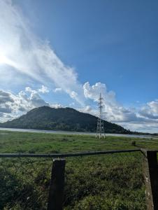 a electricity transmission tower in a field with a mountain at Hotel Villa Lake View in Kurunegala
