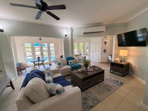 a living room with a couch and a table at Suite Escape Villa in Lowlands