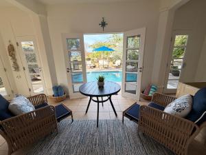 a living room with a table and chairs and a pool at Suite Escape Villa in Lowlands