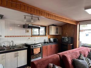 a kitchen with a red couch in a room at Ventisqueros Coyhaique in Coihaique