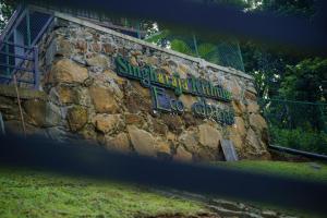 a stone wall with a sign on it at Sinharaja Kithula Eco Cabanas in Batuwangala