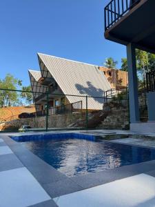 a house with a swimming pool in front of a house at Sinharaja Kithula Eco Cabanas in Batuwangala