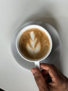 a person is holding a cup of coffee at Sinharaja Kithula Eco Cabanas in Batuwangala