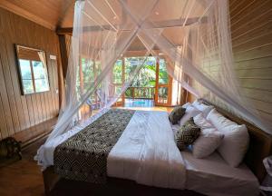 a bedroom with a bed with a mosquito net at Ella Antara Green Wood Cottage in Ella