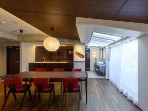 a dining room with a table and red chairs at illi Tex Aoyama in Tokyo