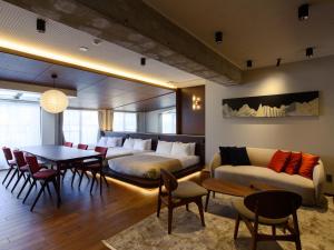 a living room with a couch and a table and chairs at illi Tex Aoyama in Tokyo