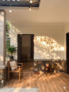 a living room with a chair and a stone wall at Nếp Nhà Homestay in Tân Phú