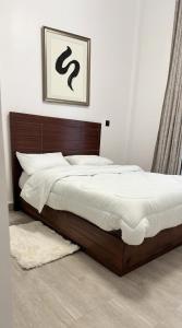 a bedroom with a large bed with white sheets at Apartment in Kitusuri in Nairobi +12 photos