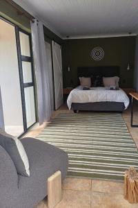 a bedroom with a bed and a large rug at Oystercatcher Guest House in Wilderness