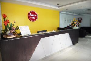 a lobby with a yellow wall and a reception desk at Brezza Hotel Lumut in Lumut