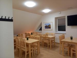 a dining room with tables and chairs and a flat screen tv at Pokoje u Strażaka in Krościenko