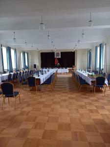 a banquet hall with tables and chairs and a stage at Pokoje u Strażaka in Krościenko