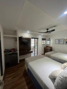 a bedroom with two beds and a flat screen tv at Hotel don Bosco in Guadalajara