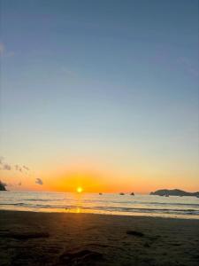 a sunset on a beach with the ocean at Hospedaje de la playa in Sámara +3 photos