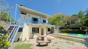 a villa with a swimming pool and a house at Hospedaje de la playa in Sámara