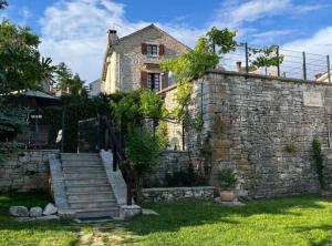 a stone house with a stone wall and stairs at Istrian Private Garden Oasis in Žminj